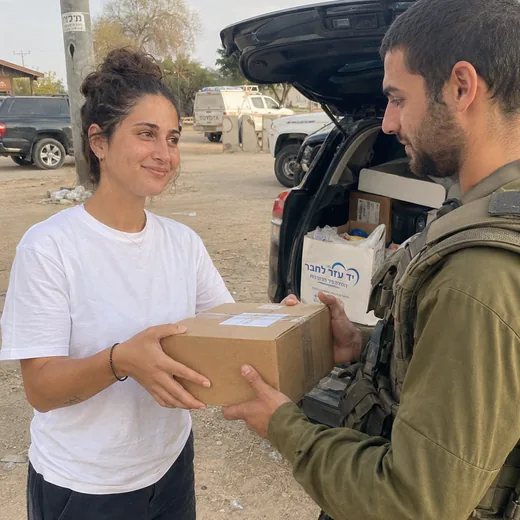 מתנדבת מוסרת חבילה ללוחם מילואים
